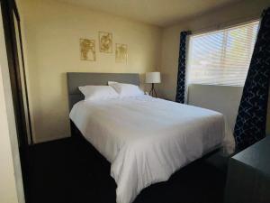 a bedroom with a large white bed with a window at 1Bd Prime Westwood Location One Block from UCLA in Los Angeles