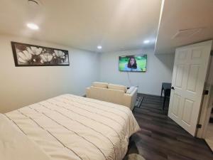 a bedroom with a bed and a couch and a tv at Modern 4BDRM Home-2 King Bed- Full House in Edmonton