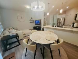 a kitchen and a living room with a table and chairs at Modern 4BDRM Home-2 King Bed- Full House in Edmonton