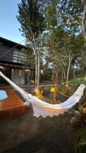a white hammock in a yard with trees at Casa.dovale2 in Caeté-Açu +7 photos