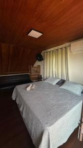a bedroom with a large bed with a wooden ceiling at Casa.dovale2 in Caeté-Açu
