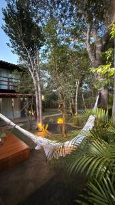 a hammock in a garden with trees and lights at Casa.dovale2 in Caeté-Açu