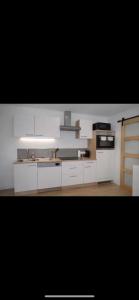 a kitchen with white cabinets and a stove top oven at Superbe 2 pièces proche parc expo in Mulhouse