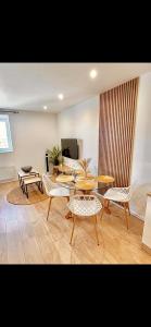 a living room with a table and chairs and a couch at Superbe 2 pièces proche parc expo in Mulhouse