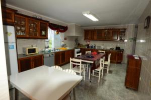 a kitchen with a table and chairs in it at Room 3 - Music House in Conceição