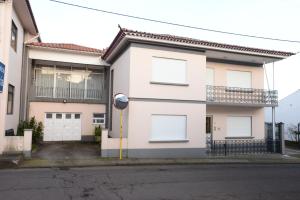 a white house with a parking meter in front of it at Room 3 - Music House in Conceição