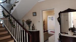 a hallway with a staircase with a mirror at Room 3 - Music House in Conceição