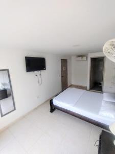 a bedroom with a bed and a flat screen tv at Hotel Taganga Plaza Santa Marta in Taganga