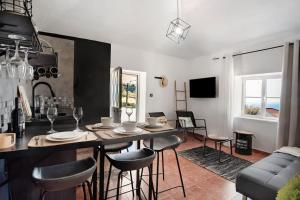 a kitchen and living room with a table and chairs at Bougainvillea House in Ponta do Pargo