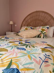 a bed with a colorful blanket and pillows on it at Maison village entre pau et lourdes in Boeil-Bezing