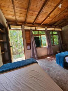 a bedroom with a bed in a room with windows at Nawal in Lanquín