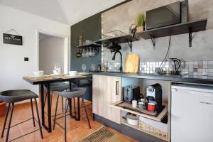 a kitchen with a counter and two bar stools at Bougainvillea House in Ponta do Pargo
