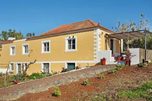 a yellow house with a garden in front of it at Bougainvillea House in Ponta do Pargo