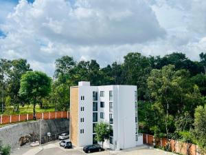 a white building with cars parked in a parking lot at Private Patio, Peaceful and Centric in Cedro