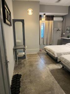 a bedroom with a bed and a table and a mirror at Roomah Ipoh En-suite attached-Bath R2 in Ipoh