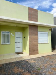 a yellow house with a white door in front at Casa Verde próxima a BR 290 in São Gabriel