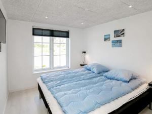 a large bed with blue pillows in a bedroom at 8 person holiday home in Læsø in Læsø