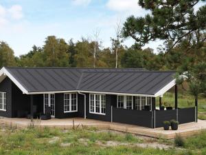 a black house with a black roof at 8 person holiday home in Læsø in Læsø