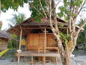 a small wooden building with a table in front of a tree at War Nyampun Homestay in Waisai