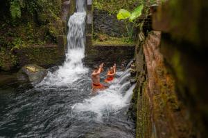 two boys in the water in front of a waterfall at Korurua Dijiwa Ubud in Ubud +44 photos