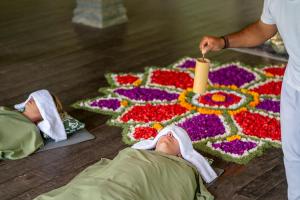 two babies laying on the floor in front of a flower rug at Korurua Dijiwa Ubud in Ubud