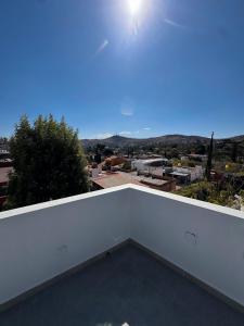 a white balcony with a view of the city at Cielo Suites in Oaxaca City