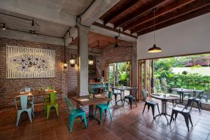 a restaurant with tables and chairs and a brick wall at Korurua Dijiwa Ubud in Ubud