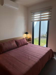 a bedroom with a large bed with a large window at Cielo Suites in Oaxaca City