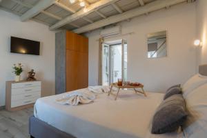 a white bedroom with a bed and a table at Vista Magica in Chania