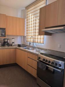 a kitchen with a sink and a stove top oven at Cielo Suites in Oaxaca City