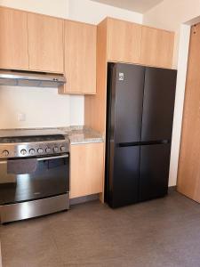 a kitchen with a black refrigerator and a stove at Cielo Suites in Oaxaca City +15 photos