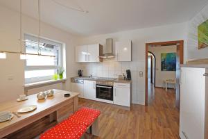 a kitchen with white cabinets and a red rug at Speyer auf Zeit - FeWo & Boardinghouse in Speyer