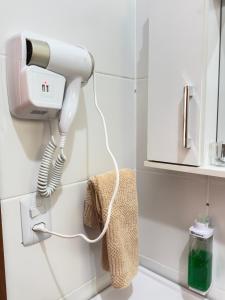 a hair dryer on the wall of a bathroom at Casa Verde próxima a BR 290 in São Gabriel