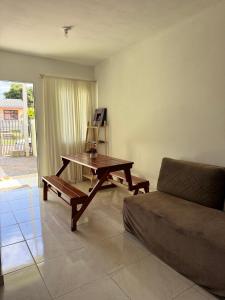 a living room with a table and a couch at Casa Verde próxima a BR 290 in São Gabriel