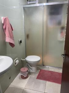 a bathroom with a shower and a toilet and a sink at Quarto Privado em Apto Bigorrilho in Curitiba +3 photos
