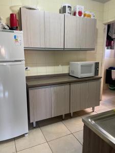 a kitchen with a refrigerator and a microwave at Quarto Privado em Apto Bigorrilho in Curitiba