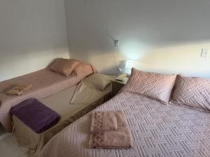 two beds sitting next to each other in a bedroom at Casa Verde próxima a BR 290 in São Gabriel