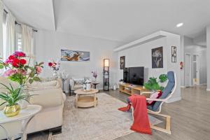 a living room with a couch and a tv at Spacious & Comfy Upper Floor 3BR Suite in Detached House in Calgary