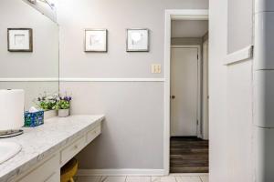 a white bathroom with a sink and a mirror at Abbies Place in Pine Bluff in Pine Bluff +35 photos
