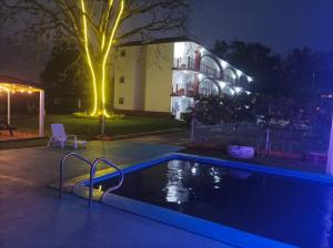 a swimming pool in front of a building at night at Hotel Los Cedros in Martínez de La Torre