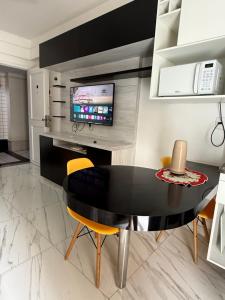 a dining room with a black table and yellow chairs at Ocean Flat com vista pro mar 604 in Vila Velha