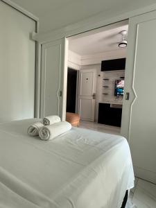 a bedroom with a white bed with towels on it at Ocean Flat com vista pro mar 604 in Vila Velha +38 photos