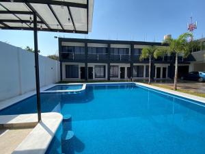 a large blue swimming pool in front of a building at Oasis Hotel Jojutla in Vallespin