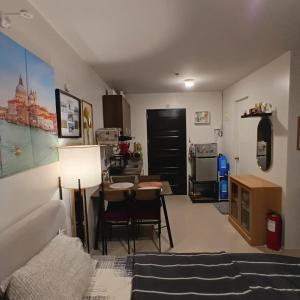 a living room with a bed and a dining room at Comfy WalkUp Studio Near Mactan Airport -Perfect for Travellers in Lapu Lapu City