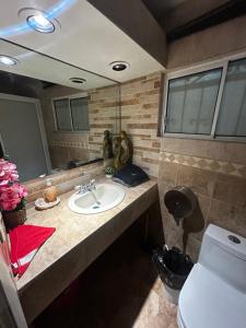 a bathroom with a sink and a mirror at Departamento 1 tecalai San Carlos, Sonora, México in Rancho El Pozo