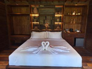 a bedroom with a bed with two hands forming a heart at Uma Cabins by Uma Experience in Penginyahan