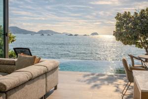 a living room with a couch and a view of the water at Fisherman Way Beach Villa in Rawai Beach +70 photos