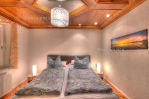 a bedroom with a bed with blue pillows and a ceiling at Ferienwohnung Am Kreidebach - zentral in Sagard - Hunde willkommen in Sagard
