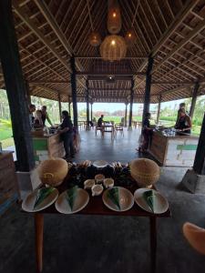 a table with plates of food on it in a room at Uma Cabins by Uma Experience in Penginyahan
