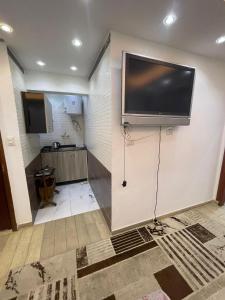 a room with a flat screen tv on a wall at استديوهات3 Hs Hotels استديو مخدوم in Cairo